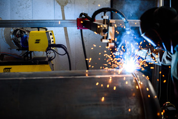 Bright orange sparks during metal grinding in heavy industry plant