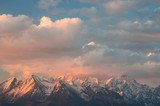 Fototapeta Niebo - Beautiful clouds illuminated by the rising sun over High Tatra mountains covered with snow, Poland