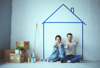 Couple sitting in front of painted home on wall