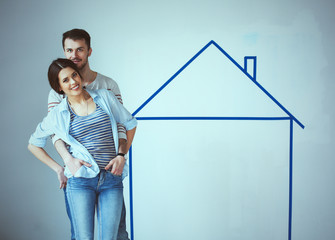 Couple standing in front of painted home on wall