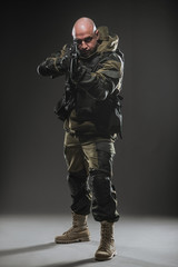 Wall Mural - soldier man hold Machine gun on a  dark background