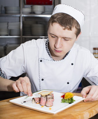 Wall Mural - chef preparing food in the kitchen at the restaurant