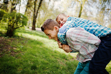 Two brother boy with headphones having fun on park. Brother love