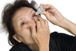 A picture of an elderly woman applying eye-drops over white back