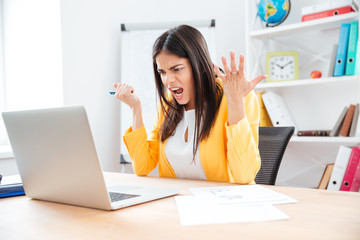 Wall Mural - Angry businesswoman using laptop computer