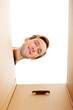 © Piotr Marcinski - Happy young man looking inside box