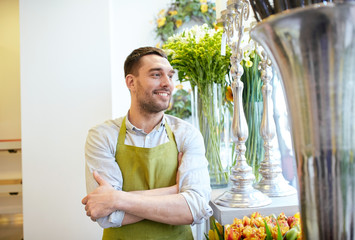 happy smiling florist man standing at flower shop