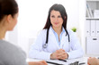 © rogerphoto - Brunette female doctor talking to patient in the hospital