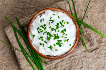 Canvas Print - Cottage cheese with chives in wooden bowl. background