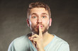 © Voyagerix - Man with finger on lips showing silence gesture.