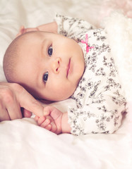 Wall Mural - Baby girl grasping her parents finger