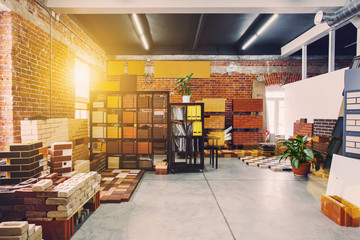 Hardware store office. Samples colored bricks. Brick wall interior. Sunlight from big window