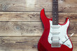 © WindyNight - Red electric guitar on grunge wooden planks background. Place fo