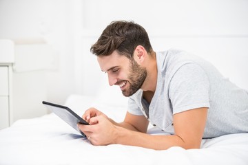 Wall Mural - Man using digital tablet on bed