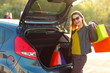 © vladstar - Caucasian woman putting her shopping bags into the car trunk
