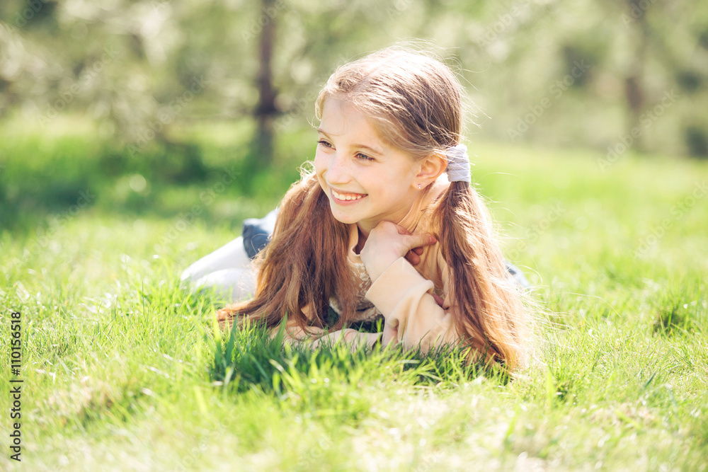 cute smiling little girl lying on the grass Stock Photo | Adobe Stock