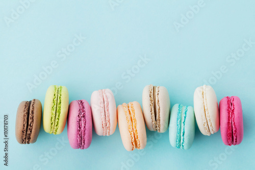Fotografie, Obraz Cake macaron or macaroon on turquoise background from above, colorful almond coo