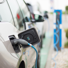 Power supply for electric car charging.  Electric car charging station. Close up of the power supply plugged into an electric car being charged.