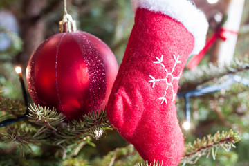 Red stocking and bauble hanging from a Christmas tree