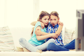 Canvas Print - scared little girls watching horror on tv at home