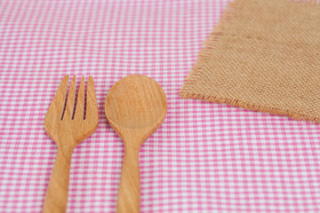 Color tablecloth, spoon, fork on  table background