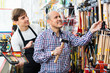 © JackF - Positive smiling customer and seller choosing hammer