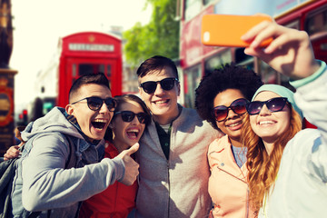 Wall Mural - smiling friends taking selfie with smartphone