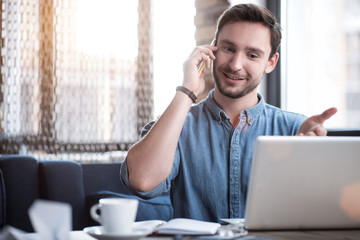 Wall Mural - Positive man talking on cell phone  