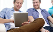 © Syda Productions - close up of happy friends with tablet pc at home