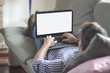 © GENETTICA - Young man lying comfortably on the sofa while using the laptop w