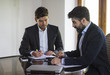 © GENETTICA - Business meeting. Young man with beard touches the screen of a t