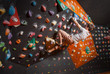 © anatoliy_gleb - Free climber young man climbing artificial boulder in gym, with climbing shoes
