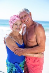 Wall Mural - Cute mature couple hugging on the beach