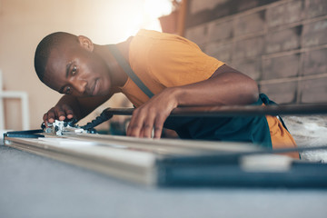 Contemporary young African artisan working with cutting tool 