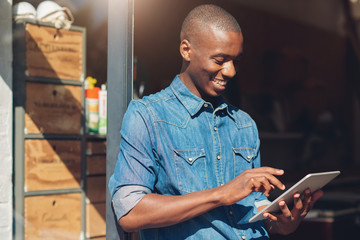 African designer and small business owner with tablet in studio