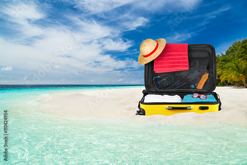 Packed suitcase on tropical...