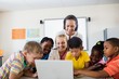 © WavebreakMediaMicro - Happy teacher and pupils using laptop