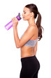 Refreshing after workout. Beautiful young woman in sports clothing drinking water and keeping eyes closed while standing over white isolated background