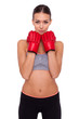 Strong and beautiful. Beautiful young sporty woman in boxing gloves looking at camera while standing against white background