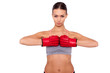 Strong and beautiful. Beautiful young sporty woman in boxing gloves looking at camera while standing against white background
