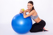 Workout snack. Portrait of a young woman sitting next to her fitness ball and eating an apple.