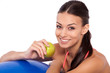 Workout snack. Cropped shot of a young attractive woman sitting next to her fitness ball and eating an apple.