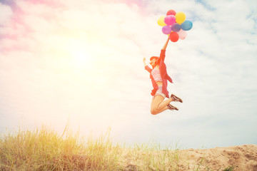 Wall Mural - Beautiful Girl jumping with balloons on the beach