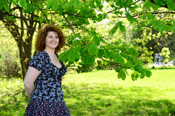 Wall Mural - woman standing in park near the chestnut