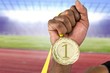 Composite image of athlete holding gold medal after victory