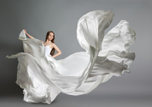 Beautiful Young Girl Dancing. The Girl In Flying White Dress. A White Cloth Is Flying In The Air. White Light Dress