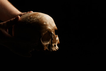 hand holding a skull is isolated on black background