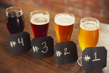 Glasses With Different Sorts Of Craft Beer And Numbering On Wooden Table. Retro Stylization