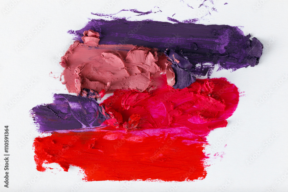 Smudged colourful lipstick on white background, close up