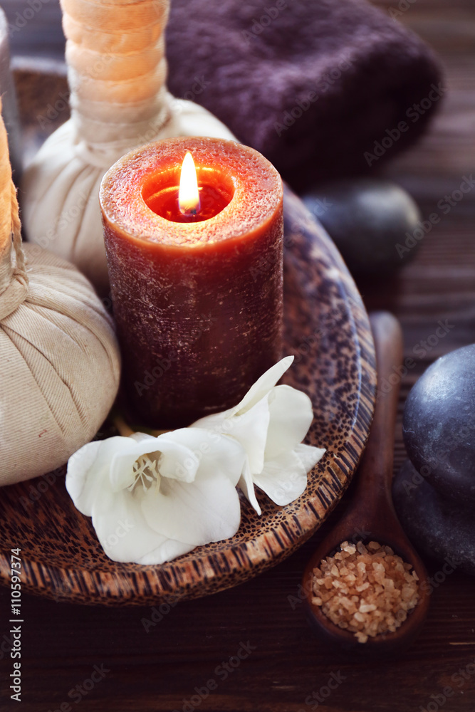 Spa composition with alight candles and beautiful flowers on wooden background